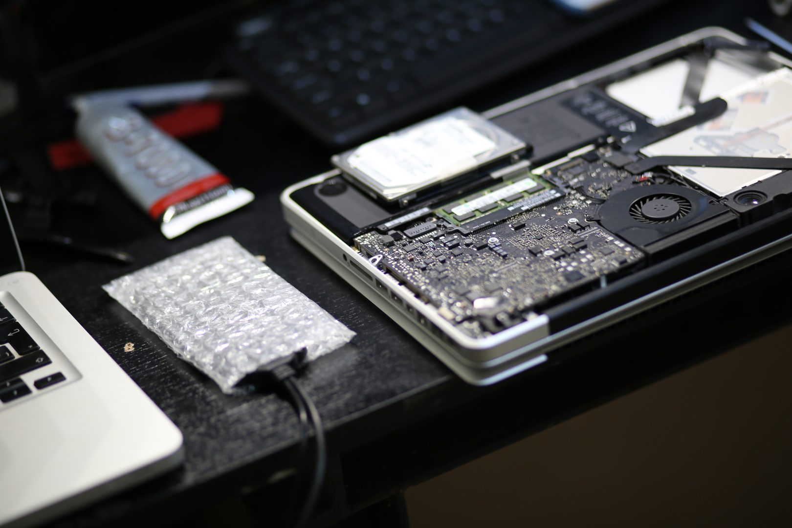 MacBook Pro abierto con placa lógica expuesta para reparación